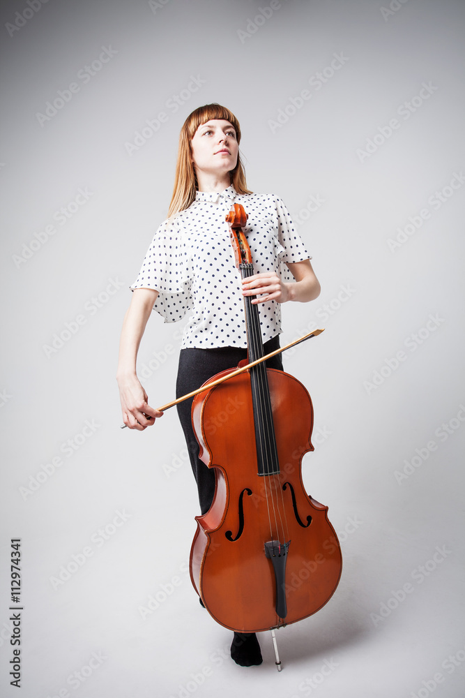 Young cellist standing and playing the cello on Young cellist standing and playing the cello on