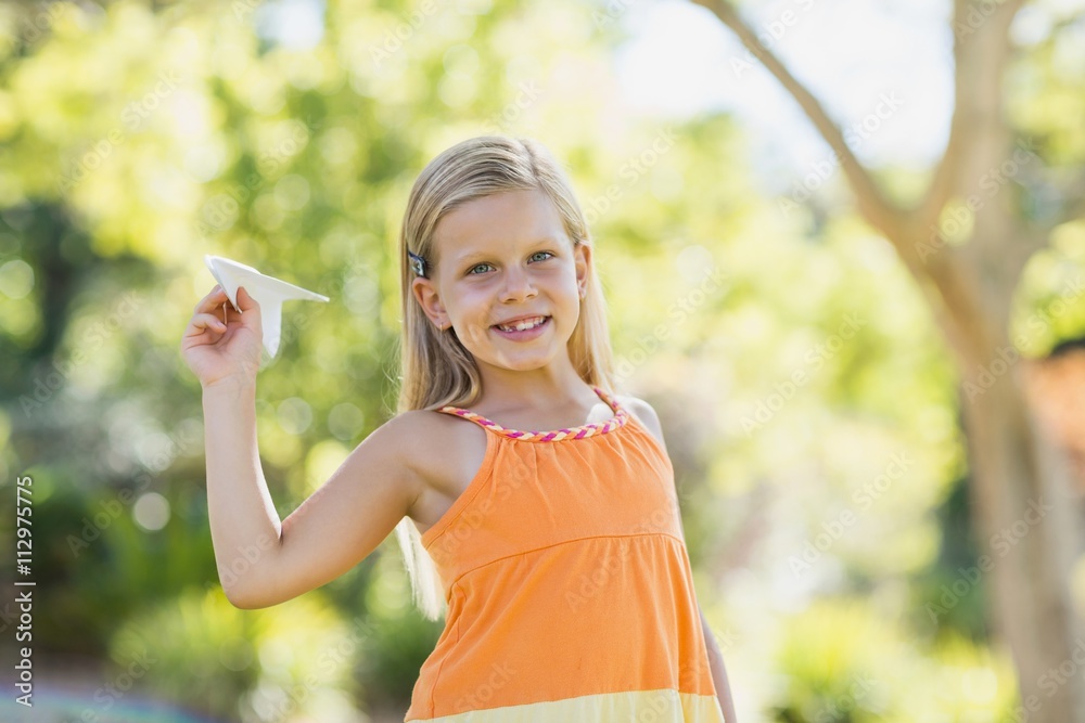 Young girl with a paper plane in park