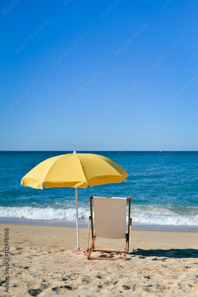 Chair and umbrella on stunning tropical beach background vacation