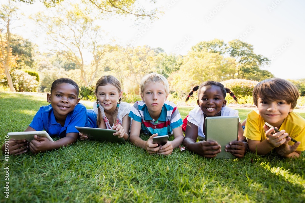 Kids using technology during a sunny day Kids using technology during a sunny day