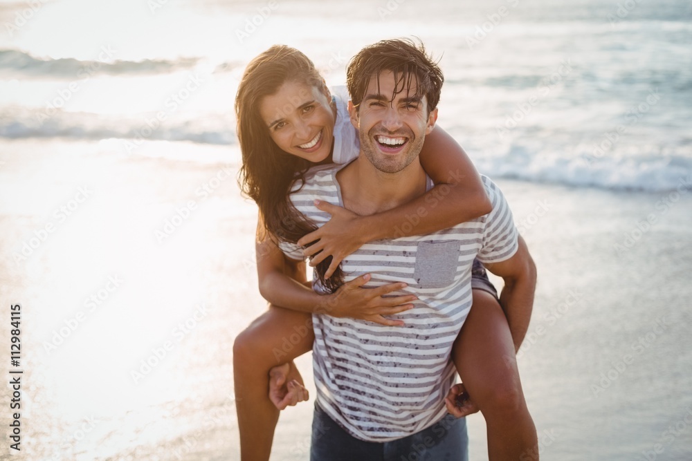 Fototapeta premium Man giving woman piggyback ride 