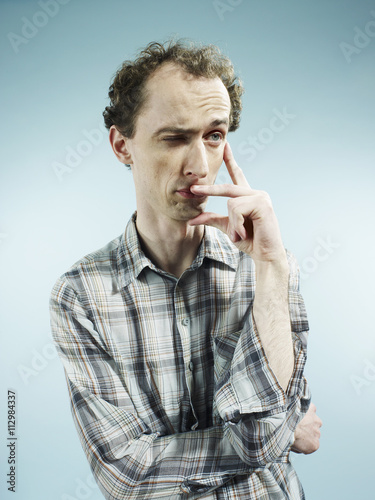 A man with an expression of uncertainty, looking away