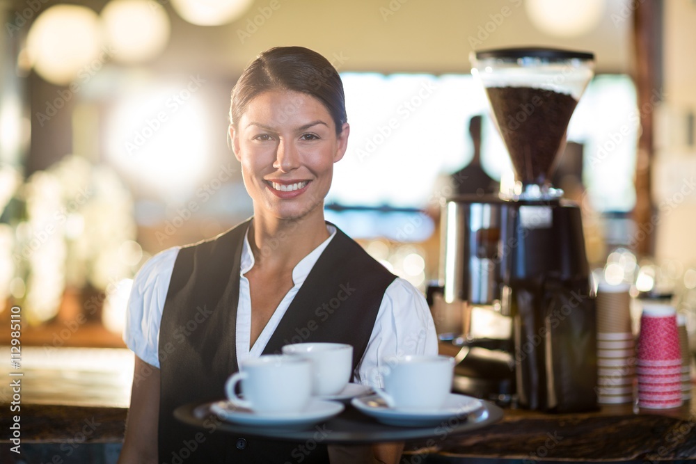 Portrait of waitress holding a tray with coffee cups Portrait of waitress holding a tray with coffee cups