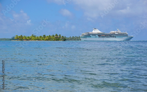Cruise ship with a tropical islet at the horizon, Huahine island, Pacific ocean, French Polynesia