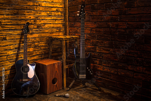 Cajon, bass and acoustic guitar on wooden stage in pub