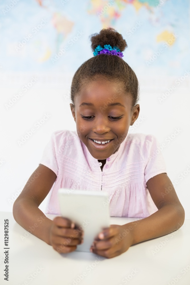 Schoolgirl using mobile phone in classroom Schoolgirl using mobile phone in classroom