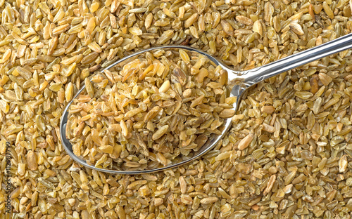 Close view of cracked freekeh grain with a spoon. photo