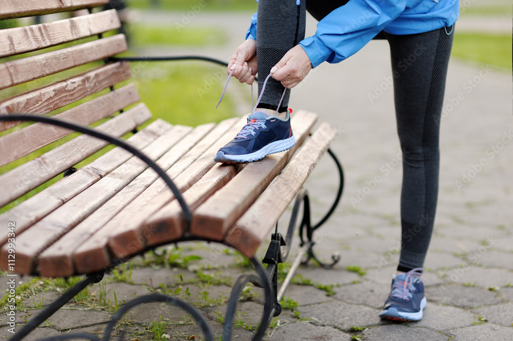 Obraz premium Woman runner tying laces before training. Marathon.