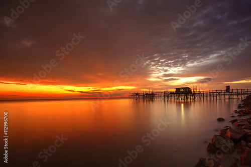 Long exposure image of "langgai" during beautiful sunset , the traditional fishing medium at Malaysia .Image has certain noise and soft focus when view at full resolution © hamdie