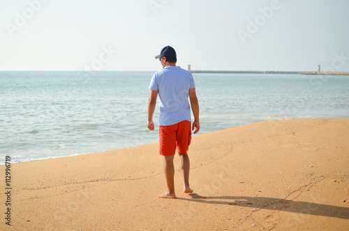 Man walking with ocean in the background. © aquar