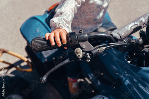 Algarve, Portugal - April 13, 2016: Small child riding a quad bike on sunny outdoors background