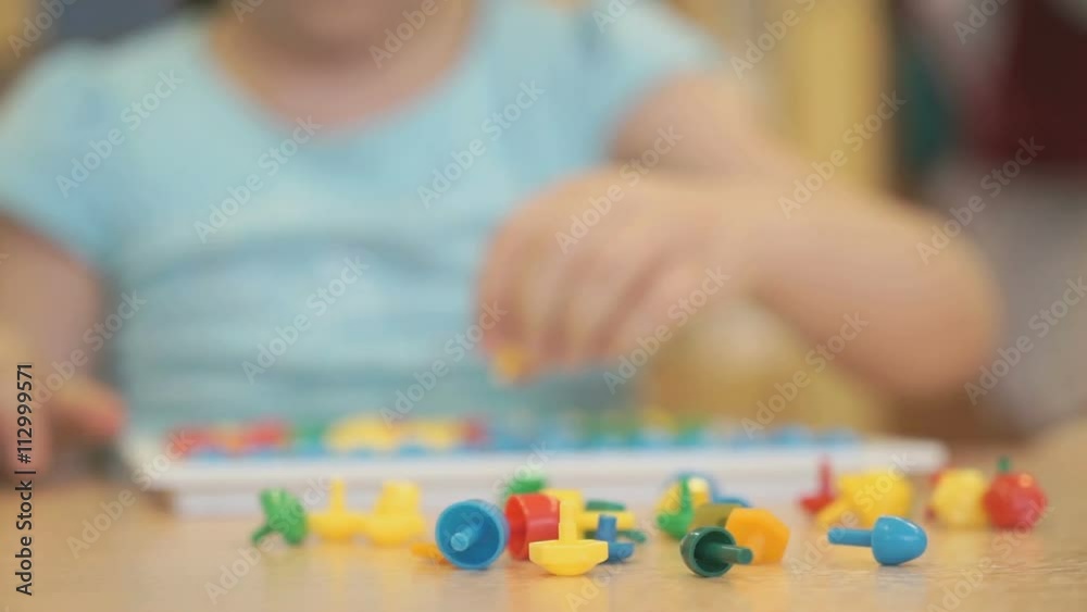 Little child plays a intellectual game at a table Little child plays a intellectual game at a table
