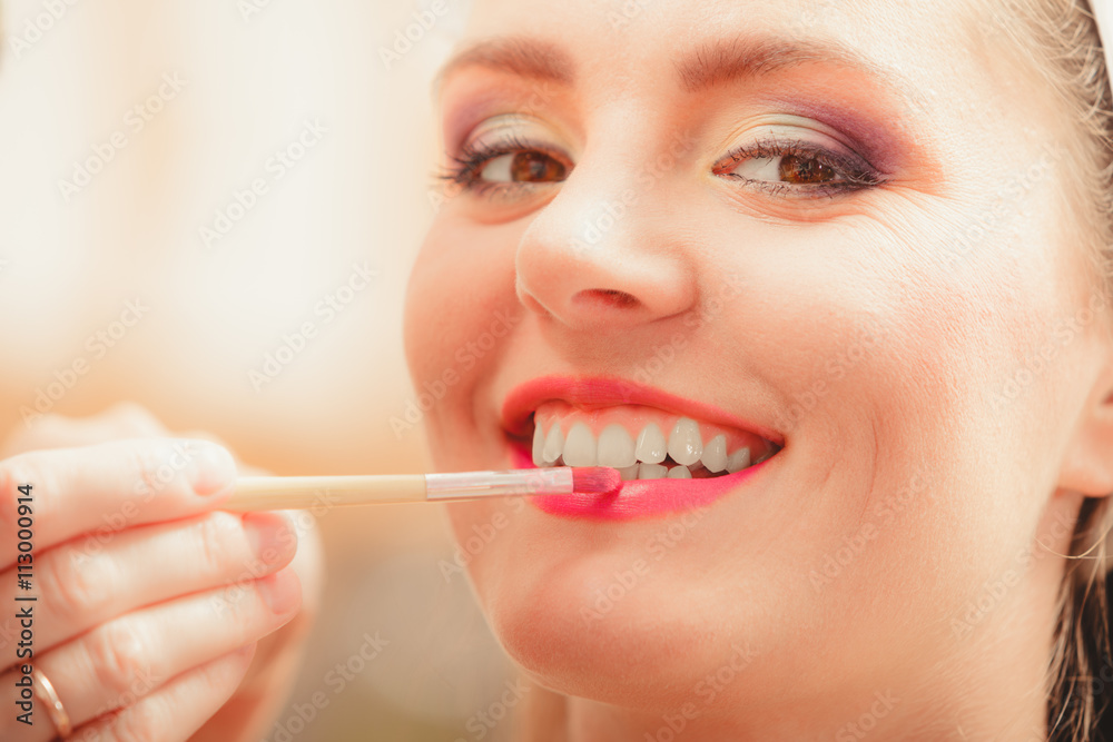 Make up artist applying lipstick with brush. Make up artist applying lipstick with brush.