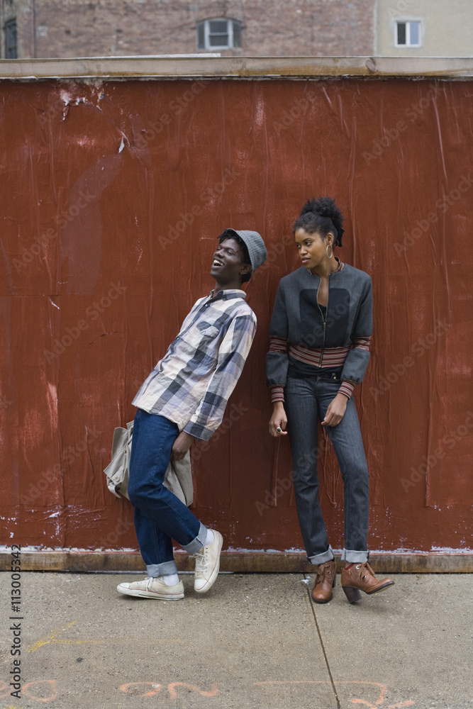 A young couple standing on a sidewalk A young couple standing on a sidewalk
