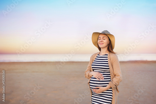 Wallpaper Mural A Portrait of pregnant young woman with a closed eyes stands and puts his hands on a belly Torontodigital.ca