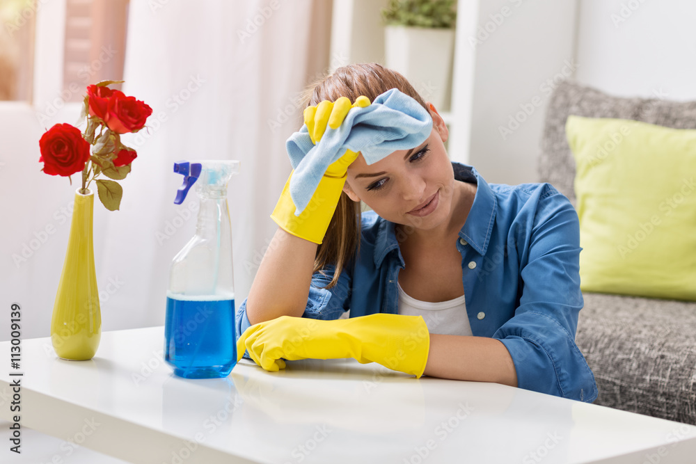 Tired frustrated and exhausted woman cleaning home Tired frustrated and exhausted woman cleaning home