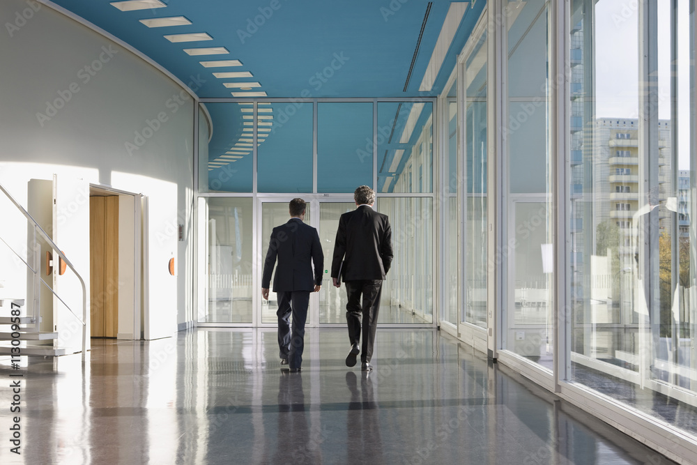 Two businessmen walking towards the exit Two businessmen walking towards the exit