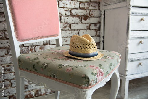 Men s hat lying on the pink chair against