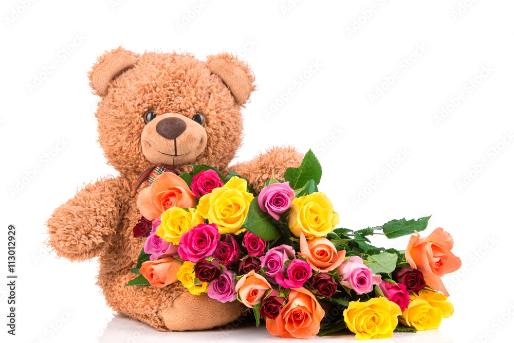 Bunch of mixed color roses and a teddy bear on white background