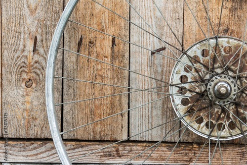 old wheel from a bicycle on a wooden background