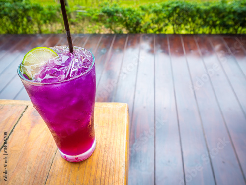 Thai traditional beverage. Ice crake lemon tea on wooden table in garden background of restaurant with copy space, Selective Focus photo