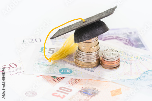 Mortarboard on top of  a stacked of coins and banknotes 