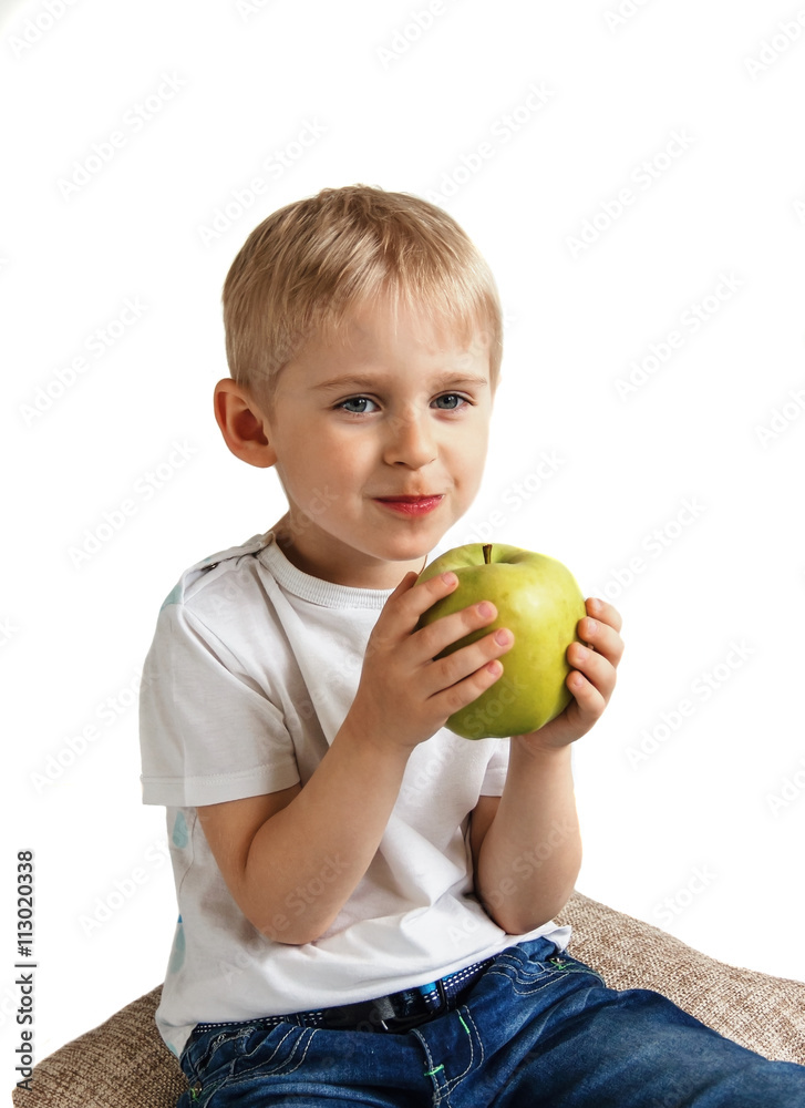 Happy cheerful boy eats the big apple, the child is the fruit gr Happy cheerful boy eats the big apple, the child is the fruit gr