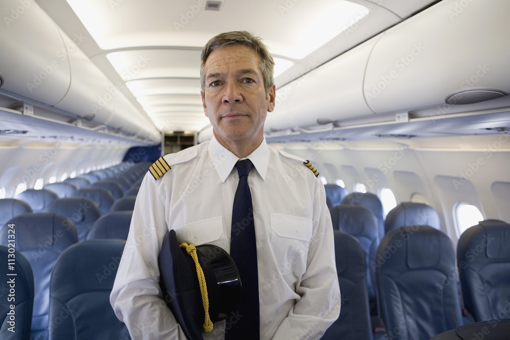 A pilot standing in the cabin of a plane A pilot standing in the cabin of a plane