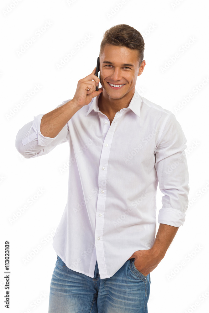 Smiling Young Man In A White Shirt On The Phone Smiling Young Man In A White Shirt On The Phone