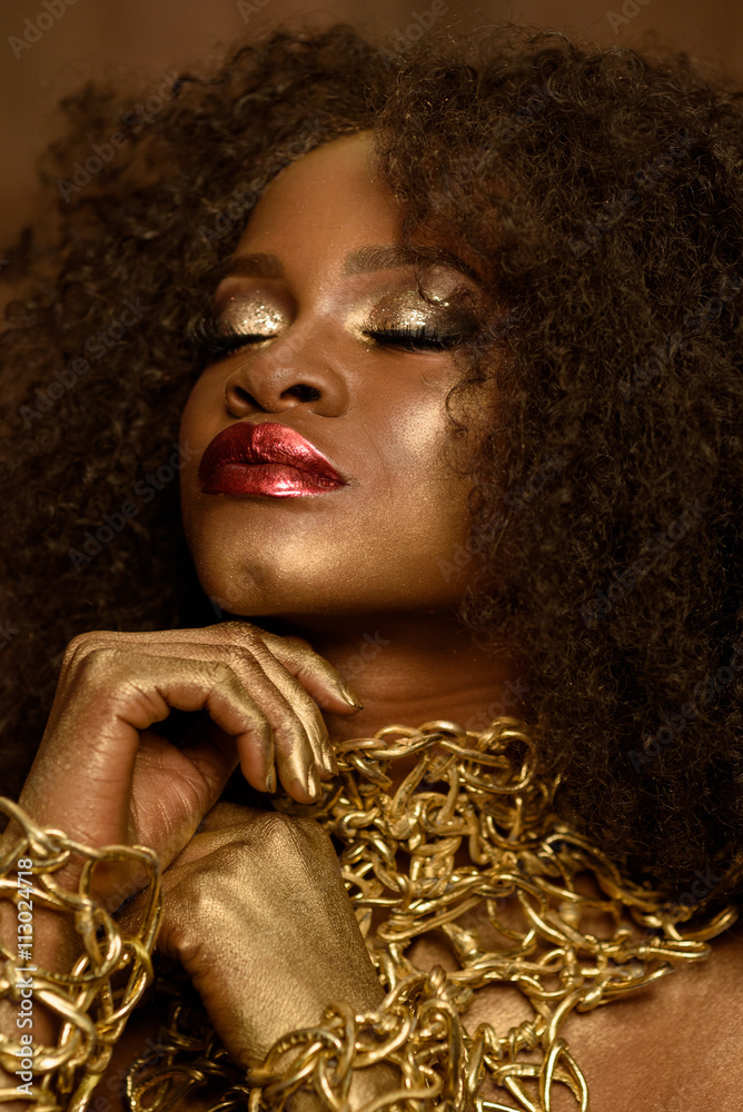 Beautiful young African woman with gold earthy makeup and necklace ...