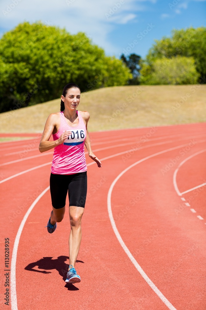 Female athlete running on the running track