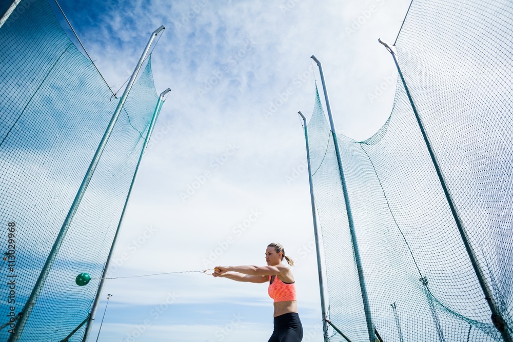 Female athlete performing a hammer throw Female athlete performing a hammer throw