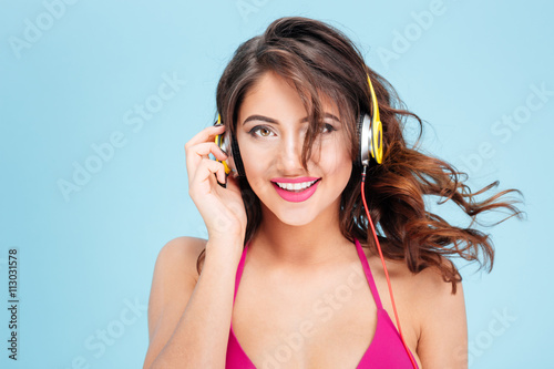 Close-up portrait of smiling girl listening music with earphones