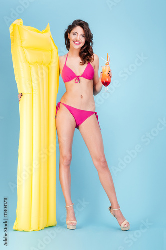 Beautiful young beach girl holding air mattress and cocktail © Drobot Dean