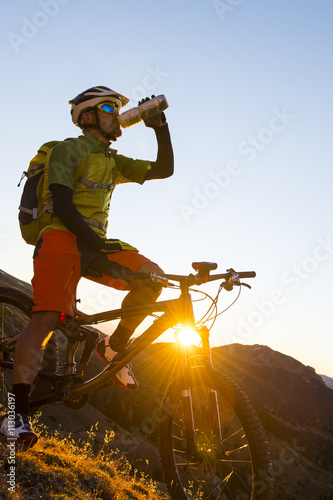 Biker drinking and enjoying the evening sun