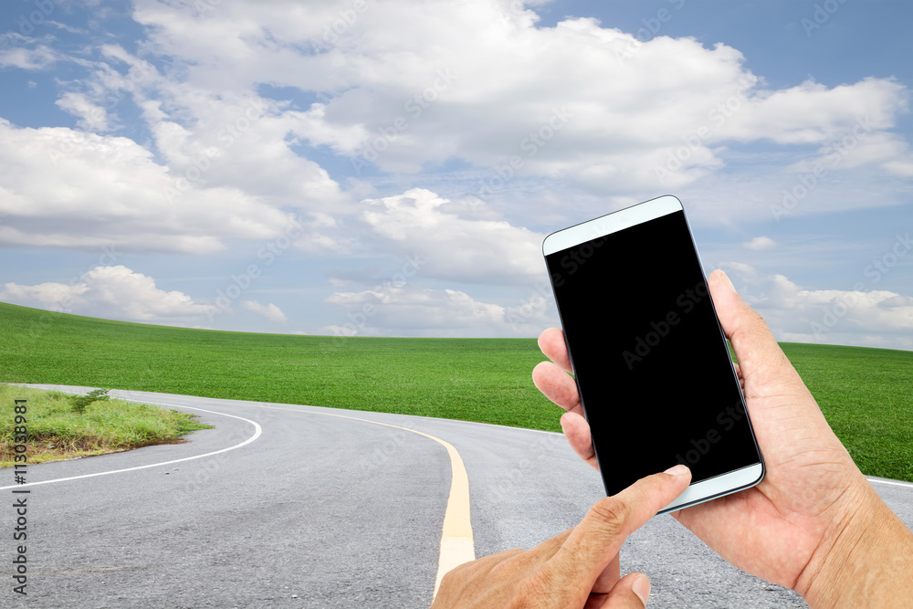 Hand  using mobile smart phone control on road curve background.