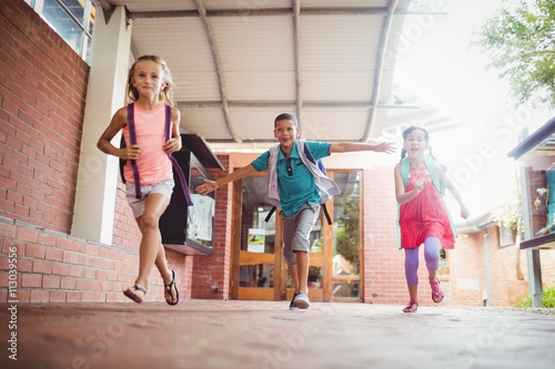Three kids running in the playground