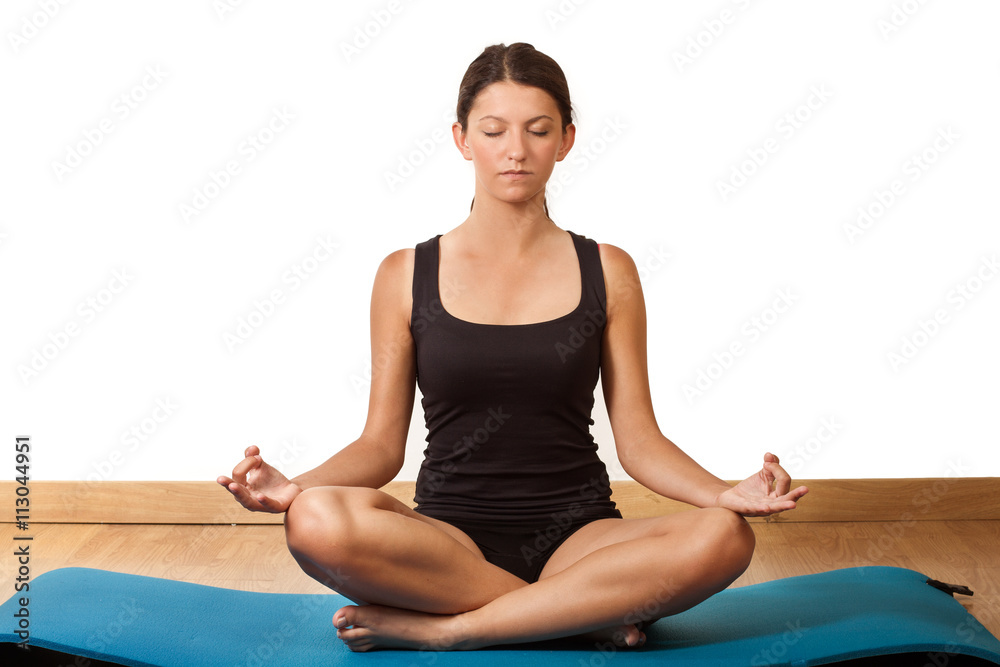 Foto de Mujer practicando yoga meditación sobre una esterilla azul