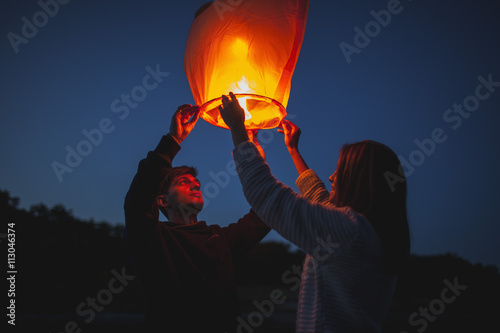 Low angle view of hikers releasing paper lanterns