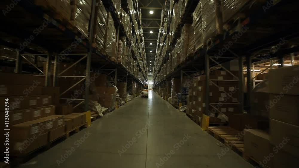 Rows of racks and loader in a huge warehouse Rows of racks and loader in a huge warehouse