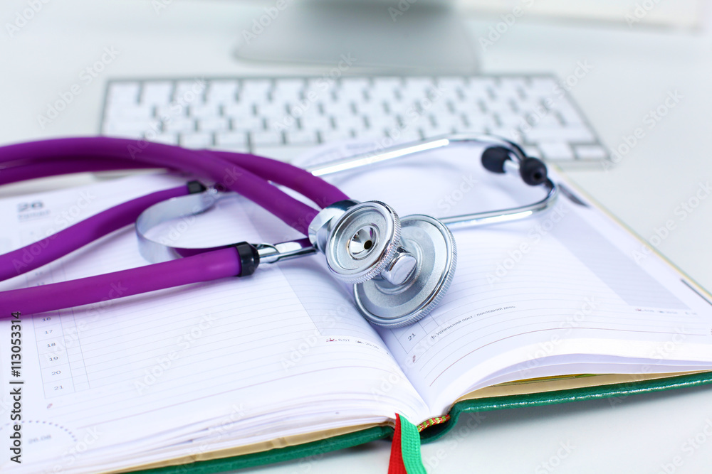 Stethoscope lying on a table on an open book Stethoscope lying on a table on an open book