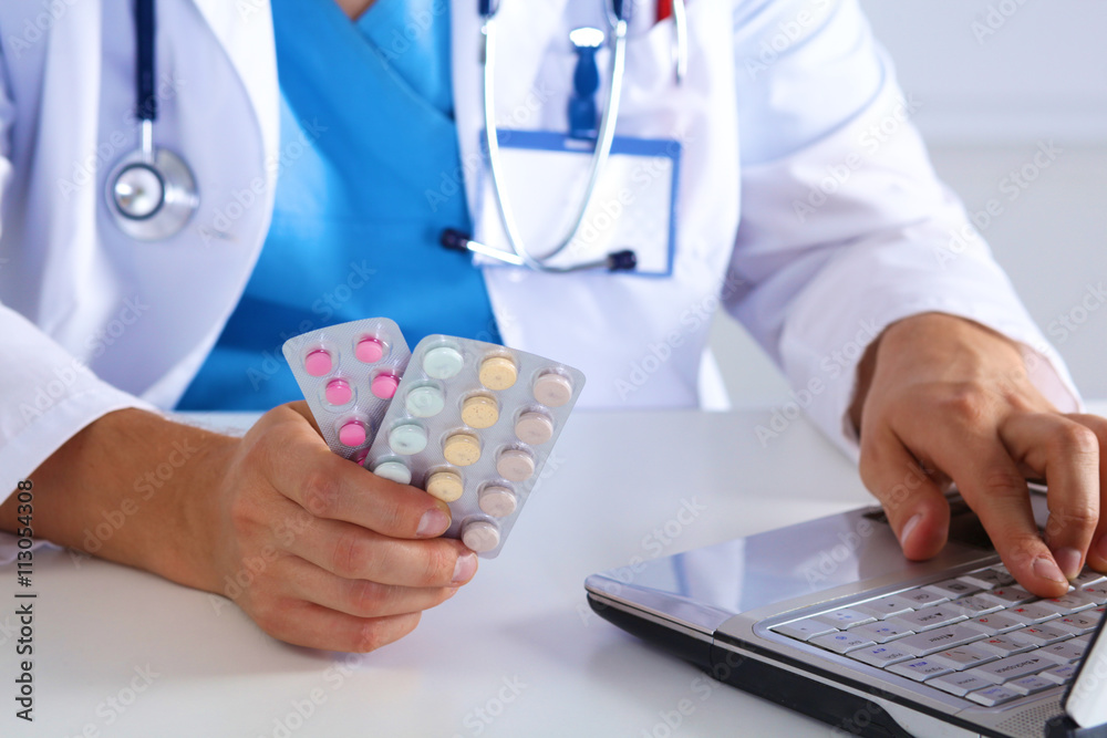 the doctor writes a prescription pill on the computer the doctor writes a prescription pill on the computer