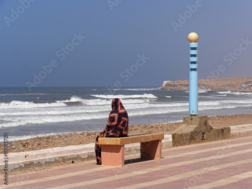auf einer Bank sitzende Muslima  in Aglou Plage an der der Atlan photo