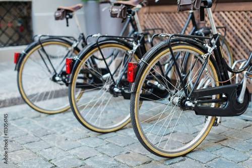 Black vintage bicycles in a bike stand © Room 76 Photography