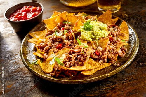 Cheese nachos with beef, guacamole and salsa
