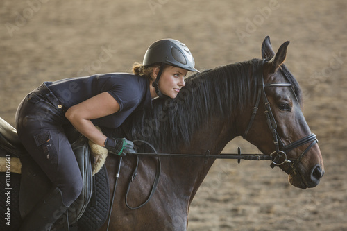 Side view of a woman riding horse on ranch