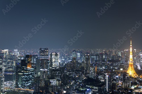 Illuminated Tokyo Tower amidst cityscape against sky at night