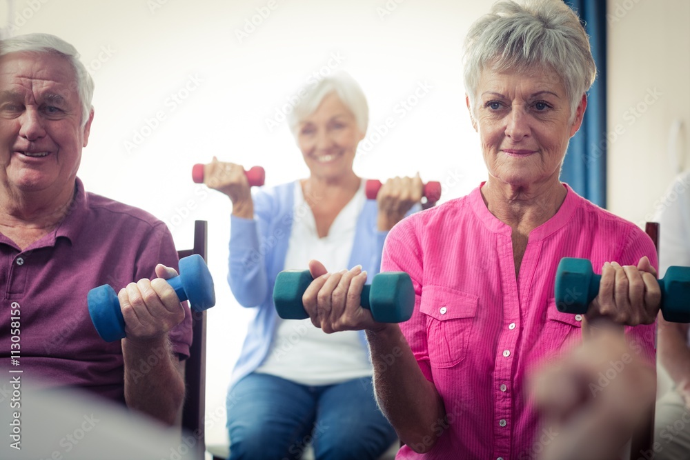 Group of seniors doing exercises with nurse