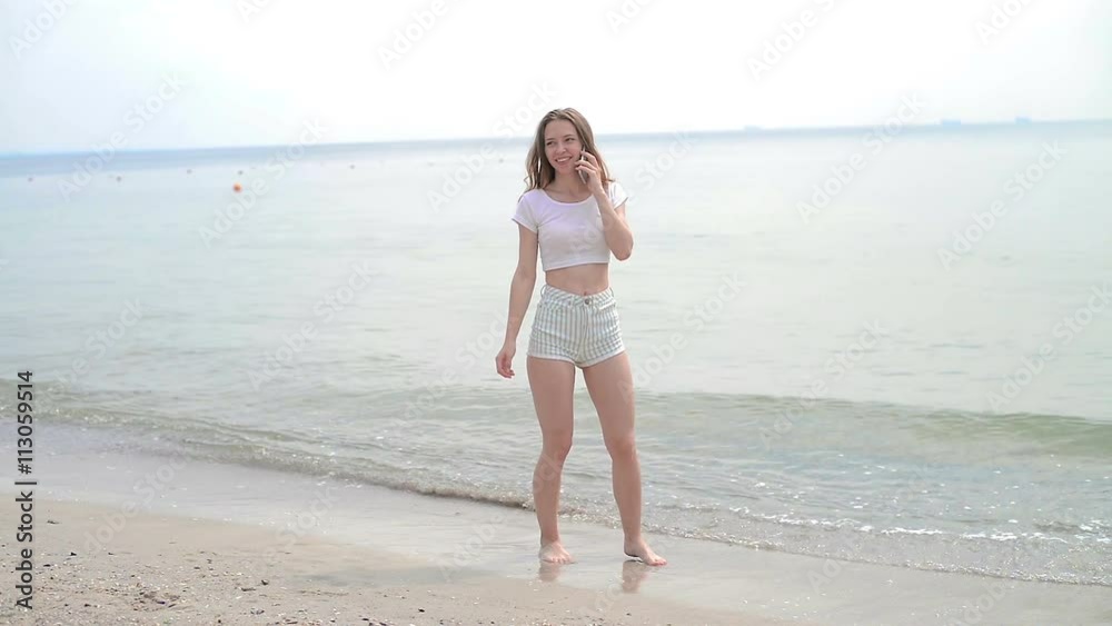 young woman with mobile phone on a beach young woman with mobile phone on a beach