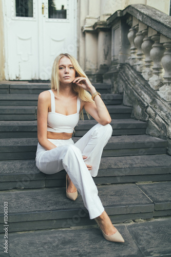 Girl sitting on the stairs of an old house architecture.